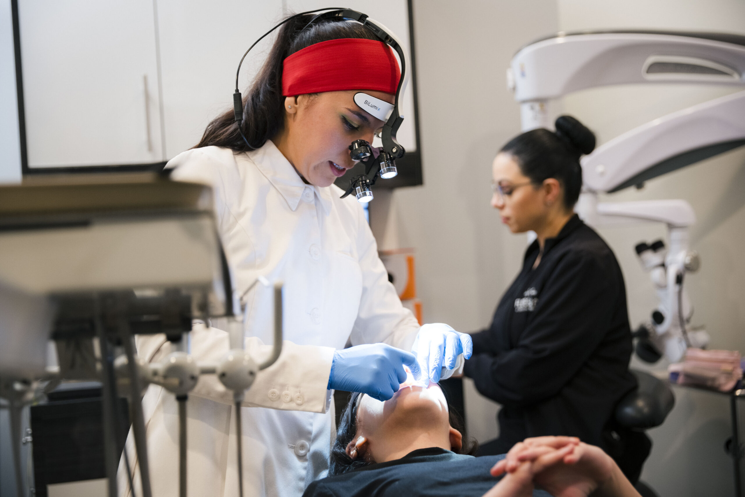 Dental hygienist using microscopic loupes during patient treatment