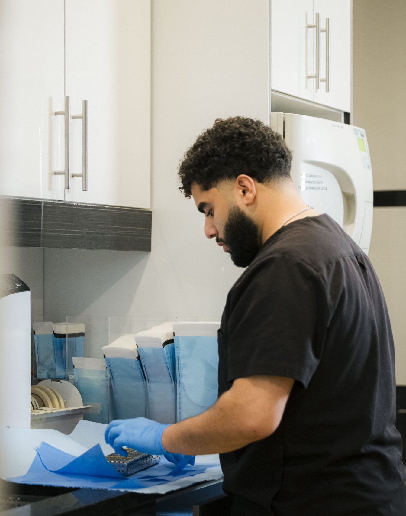Dental assistant preparing instruments at sterilization station