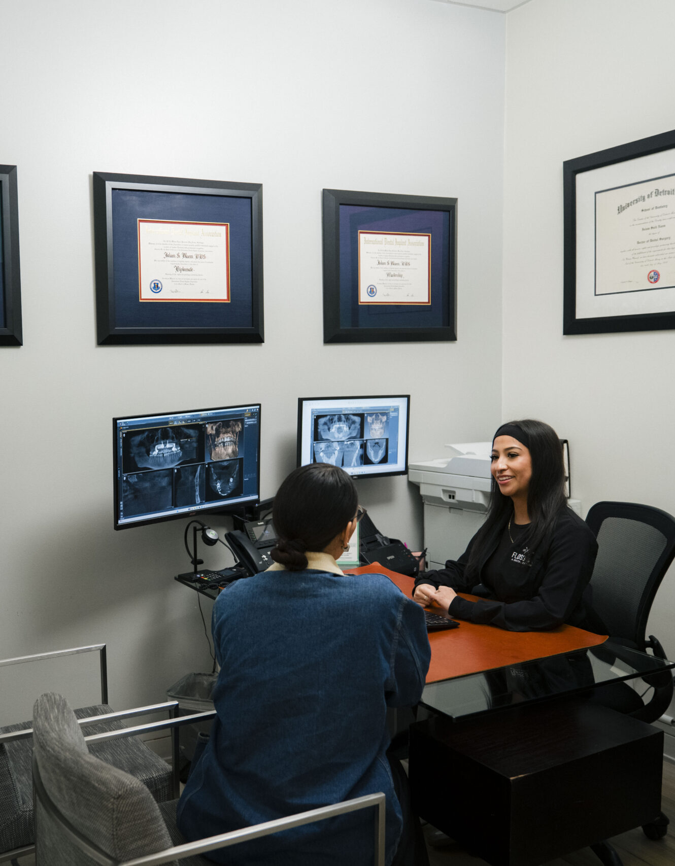 The Holistic Airway Dentist consultation room with dentist reviewing dental X-rays with patient at desk.