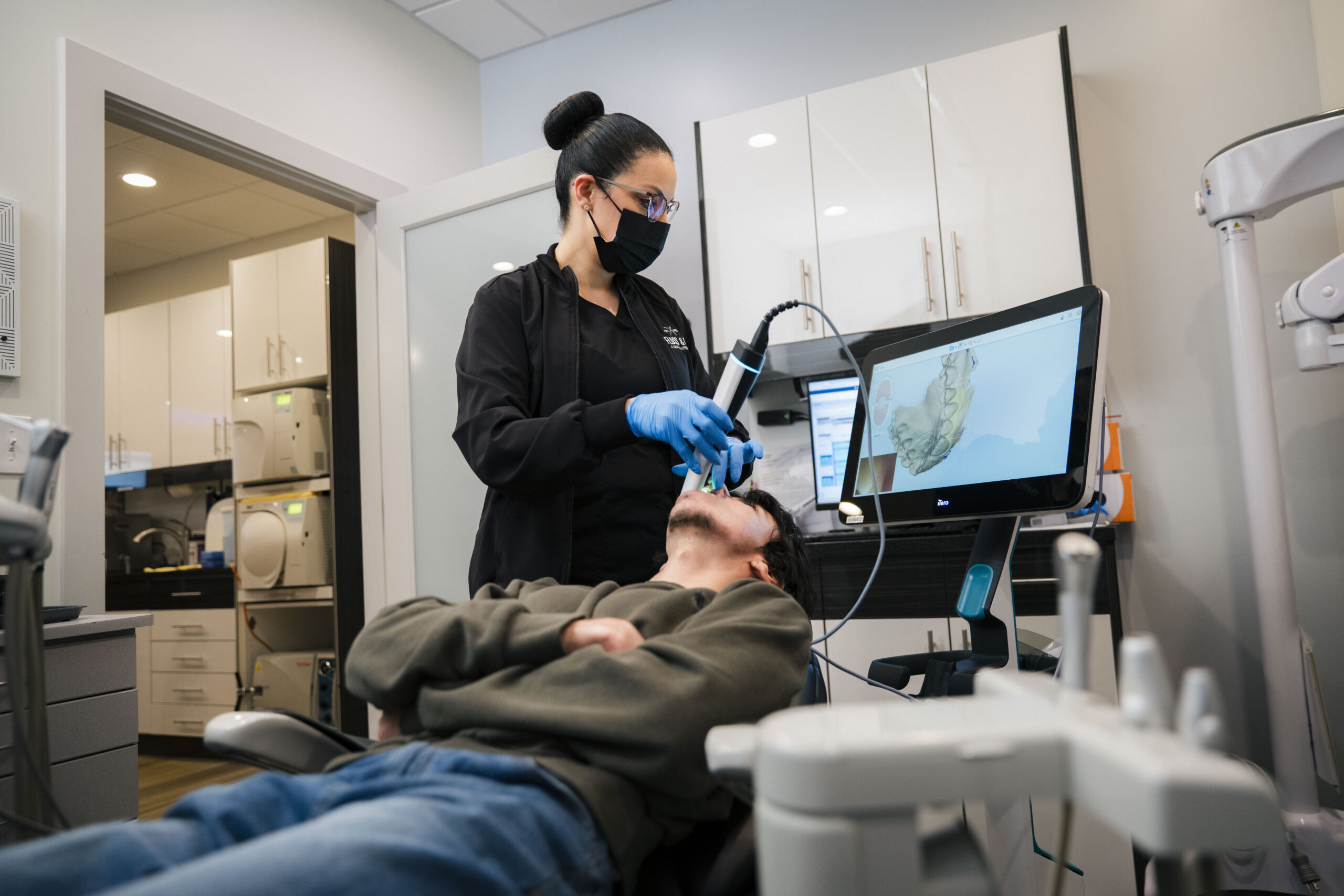 The Holistic Airway Dentist clinician using intraoral scanner to capture digital dental impressions during patient exam.